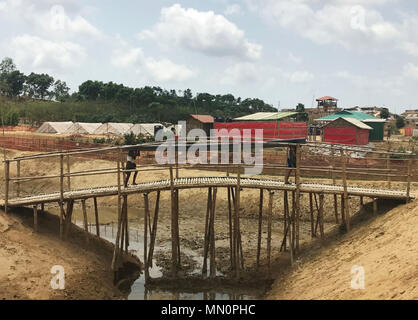 De 0001 sous embargo Lundi 14 mai un homme porte les matériaux de construction à travers un pont de bambou dans le camp de réfugiés d'Balukhali au Bangladesh. Lundi 14 mai 2018. Femmes rohingyas qui ont fui leurs foyers en Birmanie sont actuellement frappés et abandonnées par leur mari, tandis que les jeunes filles font face à une pression accrue de se marier, selon les travailleurs humanitaires. Voir l'activité de bienfaisance histoire Rohingyas. Crédit photo doit se lire : Jemma Crew/PA Wire Banque D'Images