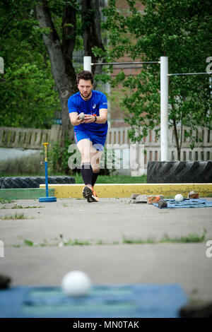 L'athlète russe Andrey Domarev jette une bille de métal pour la pétanque volo Banque D'Images