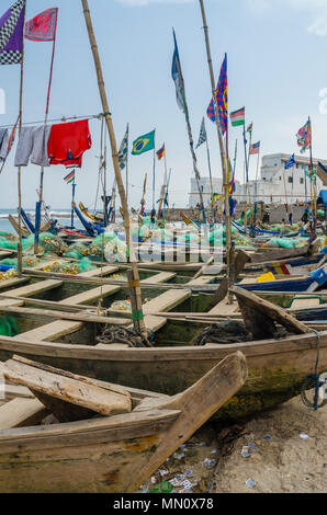 Cape Coast, Ghana - 15 Février 2014 : bateaux de pêche en bois colorés amarrés dans le port de Cape Coast ville africaine de l'époque coloniale et château en arrière-plan Banque D'Images