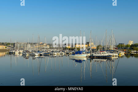 Vue paysage de bateaux dans le port de Cardiff Bay in early morning light, avec des reflets dans l'eau encore Banque D'Images