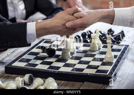 Business people shaking hands over échiquier après le jeu Banque D'Images