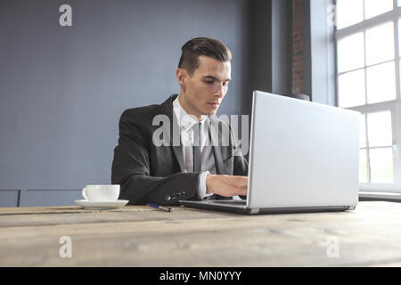 L'homme d'affaires travaillant sur un ordinateur portable sur une table en bois rustique Banque D'Images
