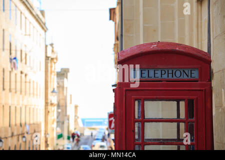 La cabine téléphonique rouge traditionnel. Blanc, vieux, pelée phone box à La Valette, Malte. L'espace pour le texte, voir la ville, de troubles de l'arrière-plan. Banque D'Images