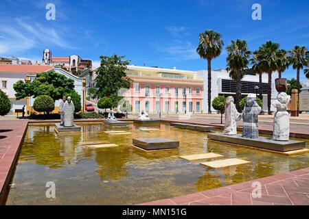 Des statues dans un bassin ornemental dans la Praca al Mutamid avec la cathédrale à l'arrière, Silves, Portugal, Europe. Banque D'Images