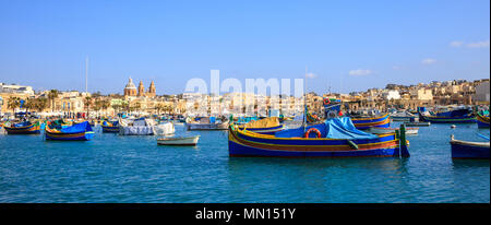 Malte, Marsaxlokk port historique plein de bateaux. Destination pour les vacances, la détente et la pêche. Le ciel bleu et le village historique. Vue rapprochée, banne Banque D'Images