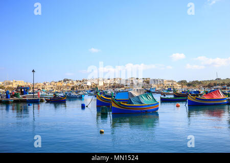 Historique de Marsaxlokk port plein de bateaux en bois à Malte. Le ciel bleu et le village historique. Destination pour les vacances, la détente et la pêche. Banque D'Images