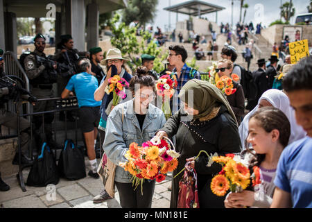 Jérusalem, Israël. 13 mai, 2018. Militants israéliens offrir des fleurs comme geste de paix pour les Israéliens et les Palestiniens alors qu'ils célèbrent le 51e anniversaire de la réunification de Jérusalem, connu sous le nom de la Journée de Jérusalem, tout en marchant à partir de la Porte de Damas au Mur Occidental à Jérusalem, 13 mai 2018. La Journée de Jérusalem est une maison de vacances israélienne commémorant la création du contrôle israélien sur la vieille ville de Jérusalem après la guerre des Six Jours de 1967. Photo : Ilia Efimovitch/dpa dpa : Crédit photo alliance/Alamy Live News Banque D'Images