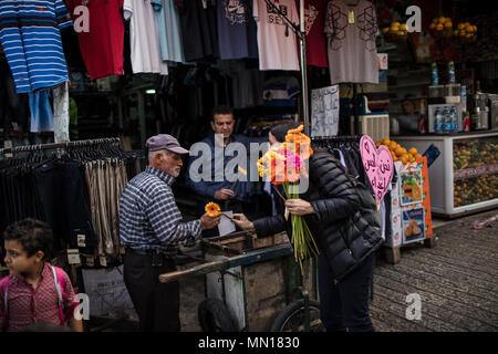 Jérusalem, Israël. 13 mai, 2018. Un activiste israélien distribue des fleurs comme un geste de paix pour les Israéliens et les Palestiniens au cours des célébrations du 51e anniversaire de la réunification de Jérusalem, connu sous le nom de la Journée de Jérusalem, dans le cadre d'une marche de la Porte de Damas au Mur Occidental à Jérusalem, 13 mai 2018. La Journée de Jérusalem est une maison de vacances israélienne commémorant la création du contrôle israélien sur la vieille ville de Jérusalem après la guerre des Six Jours de 1967. Photo : Ilia Efimovitch/dpa dpa : Crédit photo alliance/Alamy Live News Banque D'Images