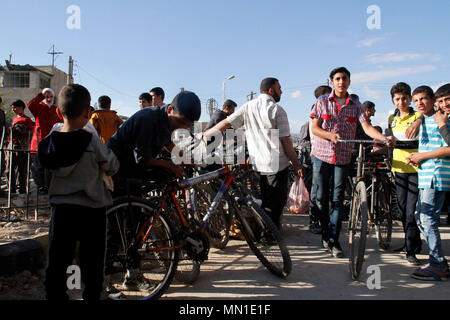 Damas, Syrie. 13 mai, 2018. Les Syriens de la bicyclette à Douma, district est de Damas, Syrie, le 13 mai 2018. Dans l'ancien quartier des rebelles de Douma, les véhicules abandonnés sans carburant pendant la guerre, qui a poussé les gens à la bicyclette comme un moyen de transport de rechange. Credit : Hummam Sheikh Ali/Xinhua/Alamy Live News Banque D'Images