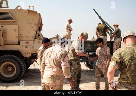 Une armée britannique trainer accompagne un membre des forces de sécurité irakiennes de déminage au cours de formation à la charge de la ligne Besmaya complexe gamme, l'Iraq, le 10 août 2017. La gamme Besmaya complexe est l'un des quatre Combined Joint Task Force - Fonctionnement résoudre inhérent à renforcer les capacités des partenaires endroits consacre à la formation des forces des partenaires et renforcer leur efficacité sur le champ de bataille. Les GFIM-OIR est la Coalition mondiale pour vaincre ISIS en Iraq et en Syrie. (U.S. Photo de l'armée par le Sgt. Tracy McKithern) Banque D'Images