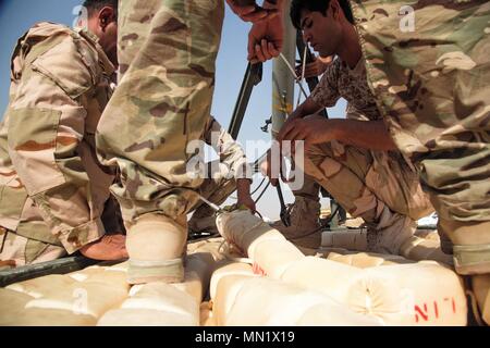 Un formateur de l'armée britannique informer un membre des forces de sécurité iraquiennes de déminage au cours de formation à la charge de la ligne Besmaya complexe gamme, l'Iraq, le 10 août 2017. La gamme Besmaya complexe est l'un des quatre Combined Joint Task Force - Fonctionnement résoudre inhérent à renforcer les capacités des partenaires endroits consacre à la formation des forces des partenaires et renforcer leur efficacité sur le champ de bataille. Les GFIM-OIR est la Coalition mondiale pour vaincre ISIS en Iraq et en Syrie. (U.S. Photo de l'armée par le Sgt. Tracy McKithern) Banque D'Images