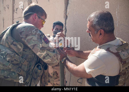 Les forces de sécurité irakiennes les membres reçoivent de l'aide d'un formateur de l'armée britannique durant le cours de génie de combat à la gamme Besmaya complexe, l'Iraq, le 8 août 2017. La gamme Besmaya complexe est l'un des quatre Combined Joint Task Force - Fonctionnement résoudre inhérent à renforcer les capacités des partenaires endroits consacre à la formation des forces des partenaires et renforcer leur efficacité sur le champ de bataille. Les GFIM-OIR est la Coalition mondiale pour vaincre ISIS en Iraq et en Syrie. (U.S. Photo de l'armée par le Sgt. Tracy McKithern) Banque D'Images