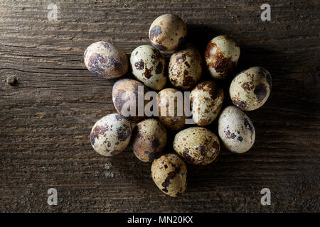 Oeufs de caille repéré organisé sur l'arrière-plan de vieux panneaux en bois, avec l'exemplaire-espace, selective focus. Naturel délicieux savoureux hors-d'œuvre. Snack-alimentaires Banque D'Images