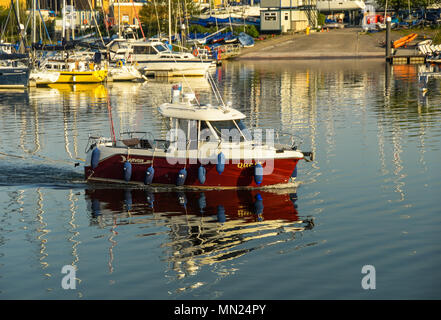 Un petit bateau de pêche avec les gens à bord de la croisière sur la baie de Cardiff in early morning light Banque D'Images