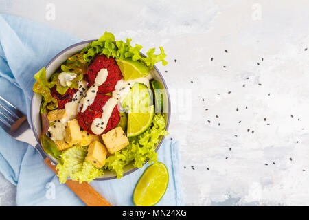 Bol bouddha végétalien boulettes de betterave, légumes, sauce tahini et cuit le tofu. La nourriture végétalienne saine concept. Banque D'Images