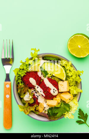 Bol bouddha végétalien boulettes de betterave, légumes, sauce tahini et cuit le tofu. La nourriture végétalienne saine concept. Banque D'Images