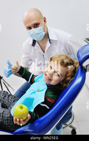 Petit enfant dans le fauteuil dentaire sur un arrière-plan du dentiste Banque D'Images