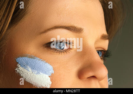 Portrait d'une femme avec le drapeau de l'Argentine peint sur son visage. Banque D'Images