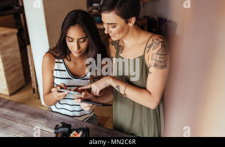 Photos de tournage blogueurs femmes coupe de fruits et jar smoothie placés le long avec un appareil photo reflex numérique pour un article sur le blog de l'alimentation. Les blogueurs à l'alimentation à la th Banque D'Images