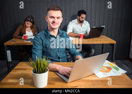 L'accent blonde man dans le bureau, l'archivage de succès que de travailler sur la tâche, occupé de la planification des étapes du projet à mes collègues de bureau marron Banque D'Images