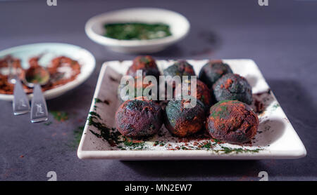 La pistache Bliss Balls couverts dans la spiruline et la poudre de cacao Banque D'Images