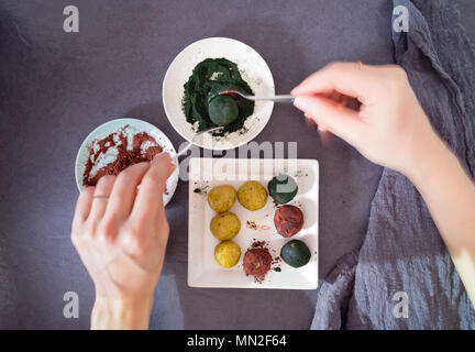 La pistache Bliss Balls couverts dans la spiruline et la poudre de cacao Banque D'Images