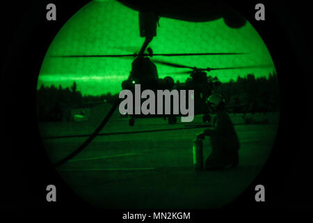 Les Marines américains avec l'Escadron de transport de ravitaillement aérien maritime (152) VMGR, ravitailler un Chinook MH-47 de l'armée américaine avec le 4-160e Special Operations Aviation Regiment (SOAR), au cours de la masse d'air délivré de nuit pour faire le plein niveau de l'unité à Evergreen formation Gray Army Airfield, Washington, 15 août 2017. VMGR-152 utilisé l'occasion au cours de la formation commune pour des instructions sur la configuration et l'utilisation d'une masse d'air délivré avec le ravitaillement 4-160e détachement du service l'airborne SOAR. La masse d'air délivré propose un ravitaillement à déploiement mobile station-service pour lieux rudimentaires pour les unités qui n'ont pas de rea Banque D'Images