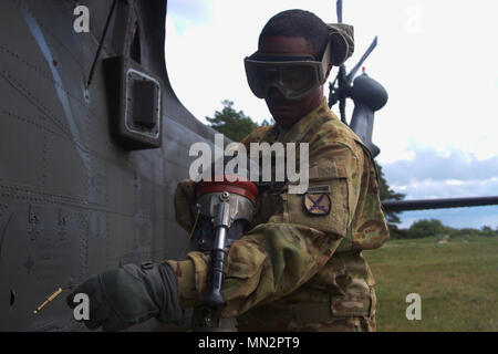 Le sergent de l'armée américaine. Thomas Ross, un fueler avec 3e Bataillon de l'aviation d'appui général, 10e Régiment d'aviation, 10e Brigade d'aviation de combat, 10e division de montagne, les finitions alimente un UH-60 Black Hawk lors de l'exercice de Falcon Talon à Liepaja, Lettonie le 20 août 2017. L'équipe de l'3-10 a été envoyé à travers la Lettonie pour leur part de Falcon's talon, une mission de l'aviation et de se soustraire à l'essai de techniques de survie contre un ennemi. (Photo prise par la FPC. Nicholas Vidro, Mobile 7e Détachement des affaires publiques.) Banque D'Images