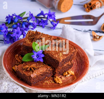 Brownie au chocolat tarte dans une assiette en céramique blanc brun sur une table en bois, vue du dessus Banque D'Images