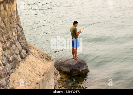 6 mai 2018 Tibériade sur la mer de Galilée en Israël. Un jeune homme tient fièrement un poisson qu'il vient de prendre à l'aide d'une canne et sur disque. Banque D'Images