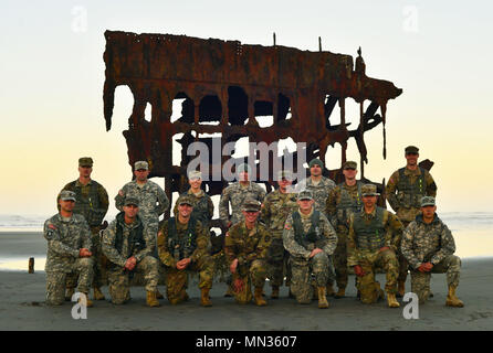 Les soldats de la Garde nationale de l'Armée de l'Oregon se rassemblent à l'aube devant l'épave du Peter Iredale après leur 12-mile ruck mars sur la plage de Fort Stevens State Park, près de Warrenton, Oregon, le 26 août 2017. Le ruck mars le coup d'envoi de la dernière journée de l'Oregon's 2017 Concours meilleur guerrier, qui a testé les soldats à la fois mentalement et physiquement pour déterminer qui allait devenir le soldat et le sous-officier de l'année et représenter l'état lors du prochain concours régional. (Photo : Capt Leslie Reed, Quartier général des Affaires publiques) Banque D'Images