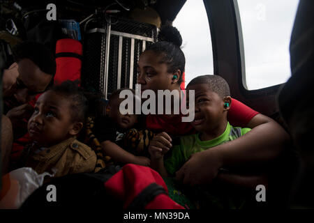 Une famille d'évacués d'attendre pour le reste de leur famille à bord d'un HH-60G Pave Hawk, affecté à la 41e Escadron de sauvetage, 30 août 2017, au cours d'une résidence dans la région de Houston, au Texas. Le 347e groupe de sauvetage de Moody Air Force Base, Ga. a répondu avec ses avions de sauvetage et du personnel à l'appui de la FEMA après l'ouragan Harvey a l'inondation et la destruction de parties du Texas. (U.S. Air Force photo de Tech. Le Sgt. Zachary Wolf) Banque D'Images