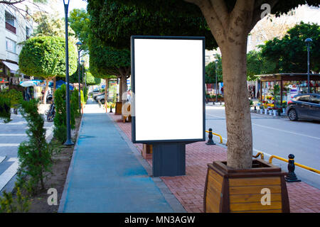 Blank billboard rue vertical stand avec arrière-plan de la ville. Banque D'Images