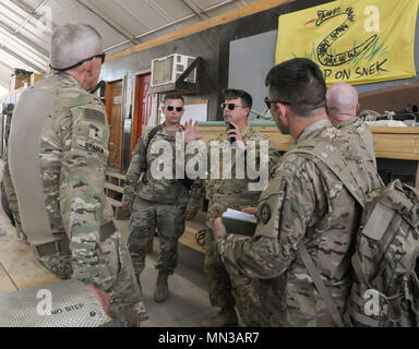 L'Adjudant chef David Willrich, 449e Bataillon de soutien à l'aviation de l'aviation de l'agent de soutien traite AH-64e phase de maintenance avec Apache, le Général Victor Braden, 35e Division d'infanterie, commandant général, au Camp Taji, l'Iraq, le 21 août 2017. Braden a fourni une orientation et des conseils qu'il a rencontré les principaux dirigeants et acquis une meilleure compréhension sur les capacités des unités subordonnées à la 35e Inf. Div. Au cours de sa visite officielle. (U.S. Photo de l'armée par le sergent. Isolda Reyes) Banque D'Images