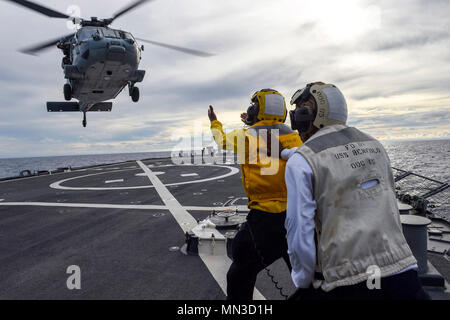 170824-N-RB168-976 PHILLIPINE SEA (Août 24, 2017) Maître de Manœuvre 3 Classe Marcus Stokes, originaire de Chicago, Illinois, diriger un MH-60 Sea Hawk, et est pris en charge par Maître de Manœuvre 2e classe Henry Jackson , originaire de Houston, au Texas, pendant les opérations de vol à bord de la classe Arleigh Burke destroyer lance-missiles USS Benfold (DDG 65) dans le cadre de la Pacific Griffin 2017. Griffin du Pacifique est un exercice entre les États-Unis et la marine de la République de Singapour (RSN), qui représente les capacités améliorées de marines à la fois d'exploiter et de travailler ensemble pour assurer la sécurité maritime et la stabilité. (U.S. Le ph de la marine Banque D'Images