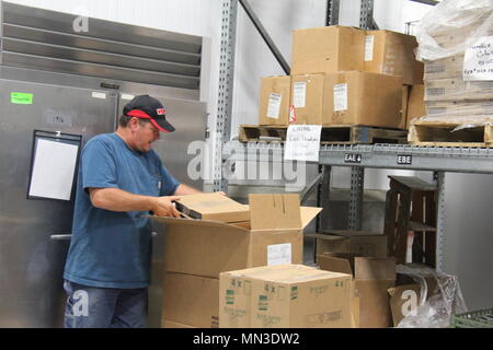 Todd Effinger, technicien en approvisionnement avec le Bureau de gestion de l'offre de subsistance, sortes aliments emballés qui ont été retournés à la SSMO par unités de formation à Fort McCoy, le 23 août 2017. La réutilisation de la SSMO veille à ce programme n'est pas gaspillé de l'alimentation après l'entraînement en faisant de la nourriture disponible pour les unités à Fort McCoy. Si la nourriture ne peut pas être utilisé par les unités qui arrivent au sein de la date d'expiration, elle est plutôt un don à l'Équipe spéciale sur la faim de La Crosse, qui distribue des fournitures à la faim d'urgence locaux et les programmes d'allégement. (U.S. Photo de l'armée par Aimee Malone, Public Affairs Office, Fort McCo Banque D'Images