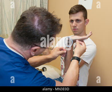 Lieutenant-colonel Dana Hess, un chirurgien dans le 60e Escadron d'opérations chirurgicales, David Grant Medical Center de l'US Air Force, examine la part de hauts Jeremy Perkins, un aviateur C-17 Globemaster chef d'équipe, avec le 860e Escadron de maintenance des aéronefs, le 22 août, 2017. Un tendon blessé Perkins dans son poignet gauche en 2013 tout en poussant une unité de puissance électrique. Il a subi une intervention chirurgicale en mai pour retirer les parties touchées du tendon et de rétrécir les ligaments. (U.S. Air Force photo/ Heide Table) Banque D'Images