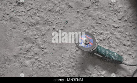 Meuleuse d'angle sur un vieux sol en béton sale. Concept de révision Banque D'Images