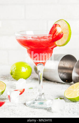 Cocktail margarita fraise froid avec de la glace, de la chaux et de baies fraîches de margarita verre, fond gris clair copy space Banque D'Images