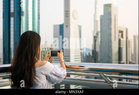 Girl taking photo de Dubai cityscape par téléphone Banque D'Images