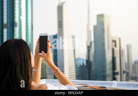 Girl taking photo de Dubai cityscape par téléphone Banque D'Images