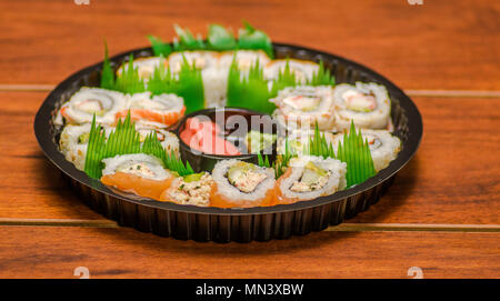 Grand ensemble de rouleaux de sushi japonais sur une plaque en plastique noir Banque D'Images