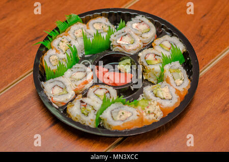 Grand ensemble de rouleaux de sushi japonais sur une plaque en plastique noir Banque D'Images