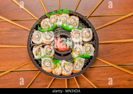 Grand ensemble de rouleaux de sushi japonais sur une plaque en plastique noir Banque D'Images