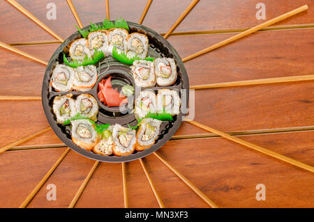 Grand ensemble de rouleaux de sushi japonais sur une plaque en plastique noir Banque D'Images