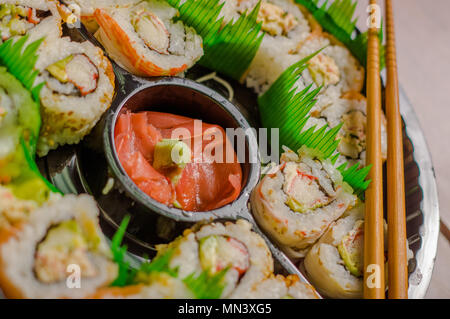 Close up of selective focus de grand ensemble de délicieux rouleaux de sushi japonais sur une plaque en plastique noir Banque D'Images