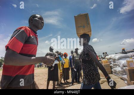7 mai 2018 - L'Ouganda, Bidi Bidi - Une femme de réfugiés soudanais du sud vu porter l'huile de palme fournie par le Programme alimentaire mondial au-dessus de sa tête..La Bidi Bidi l'établissement des réfugiés dans le nord de l'Ouganda, près de la frontière avec le Soudan du Sud est actuellement le plus grand camp de réfugiés au monde, accueillant plus de 250 000 réfugiés soudanais du sud fuyant le conflit. Le programme alimentaire mondial fournit des approvisionnements alimentaires de base mensuel pour les réfugiés dans le règlement. (Crédit Image : © Geovien/SOPA ainsi des images à l'aide de Zuma sur le fil) Banque D'Images