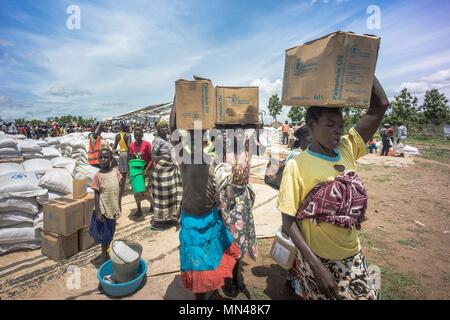 7 mai 2018 - L'Ouganda, Bidi Bidi - les femmes réfugiés soudanais du sud vu porter l'huile de palme sur le haut de leurs têtes qu'ils ont reçu ces aliments par le Programme alimentaire mondial..La Bidi Bidi l'établissement des réfugiés dans le nord de l'Ouganda, près de la frontière avec le Soudan du Sud est actuellement le plus grand camp de réfugiés au monde, accueillant plus de 250 000 réfugiés soudanais du sud fuyant le conflit. Le programme alimentaire mondial fournit des approvisionnements alimentaires de base mensuel pour les réfugiés dans le règlement. (Crédit Image : © Geovien/SOPA ainsi des images à l'aide de Zuma sur le fil) Banque D'Images