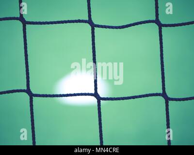 Voir à travers le football gate net. Ballon de soccer sur l'herbe verte vue par net2 Banque D'Images