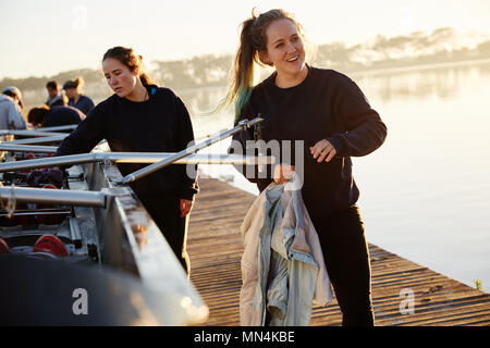 Female rower préparation scull sur rives ensoleillées dock Banque D'Images